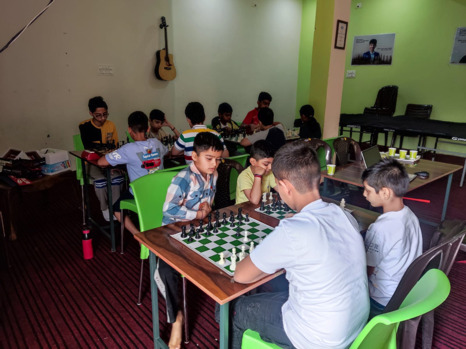 A coach guiding students during an offline chess class